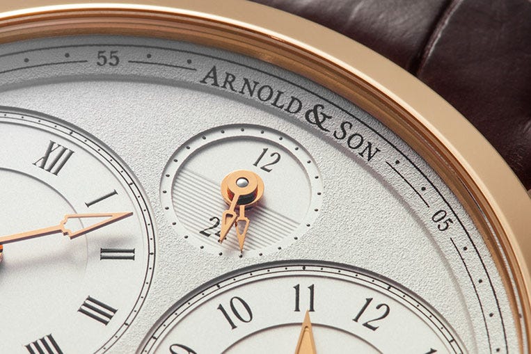 A dual twenty-four hour dial indicates day and night for the two time zones